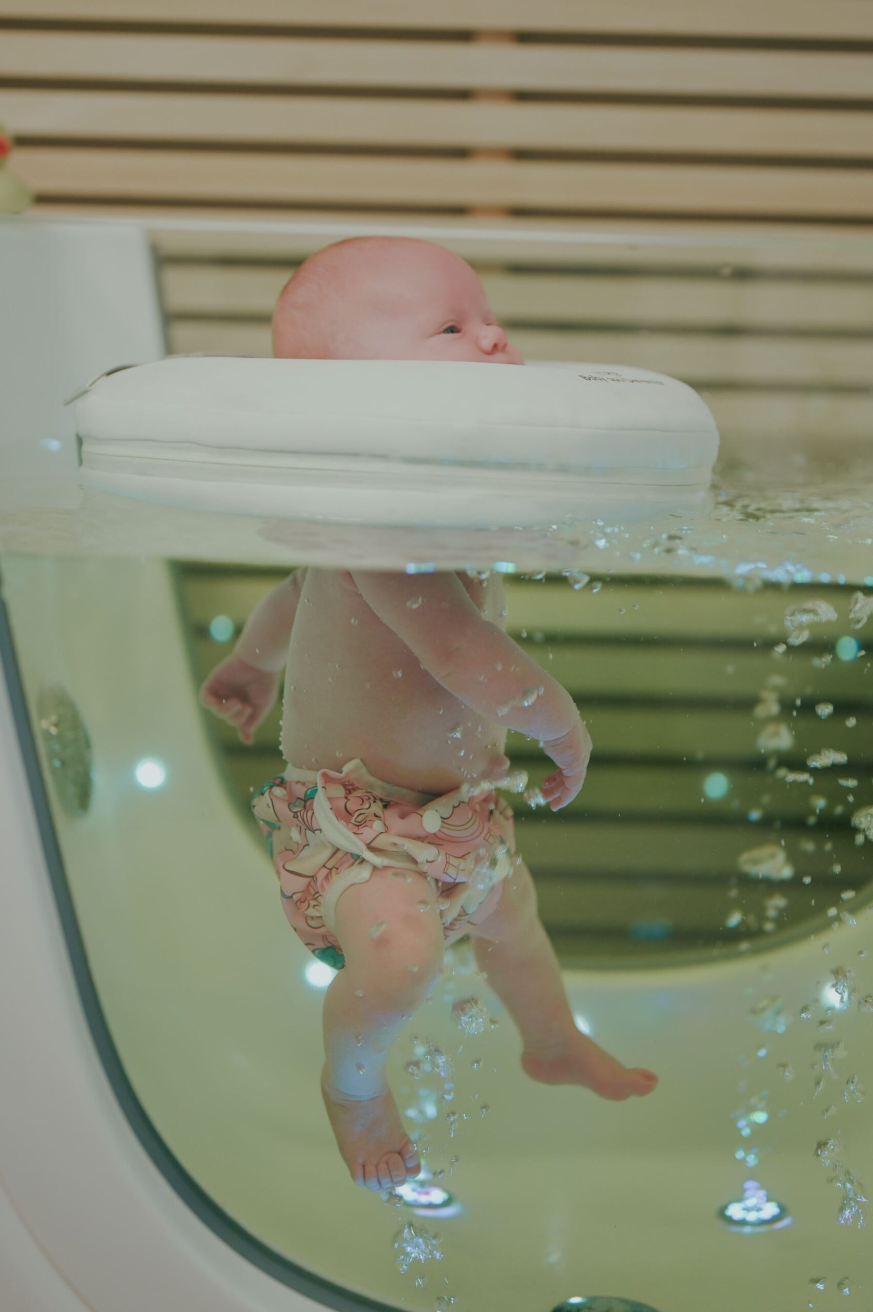 Baby met groene onderwaterverlichting
